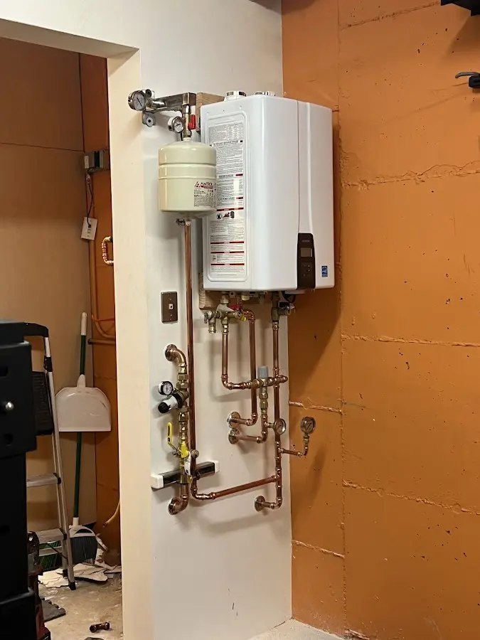 Plumbing technician inspecting water heater connections in Thruston